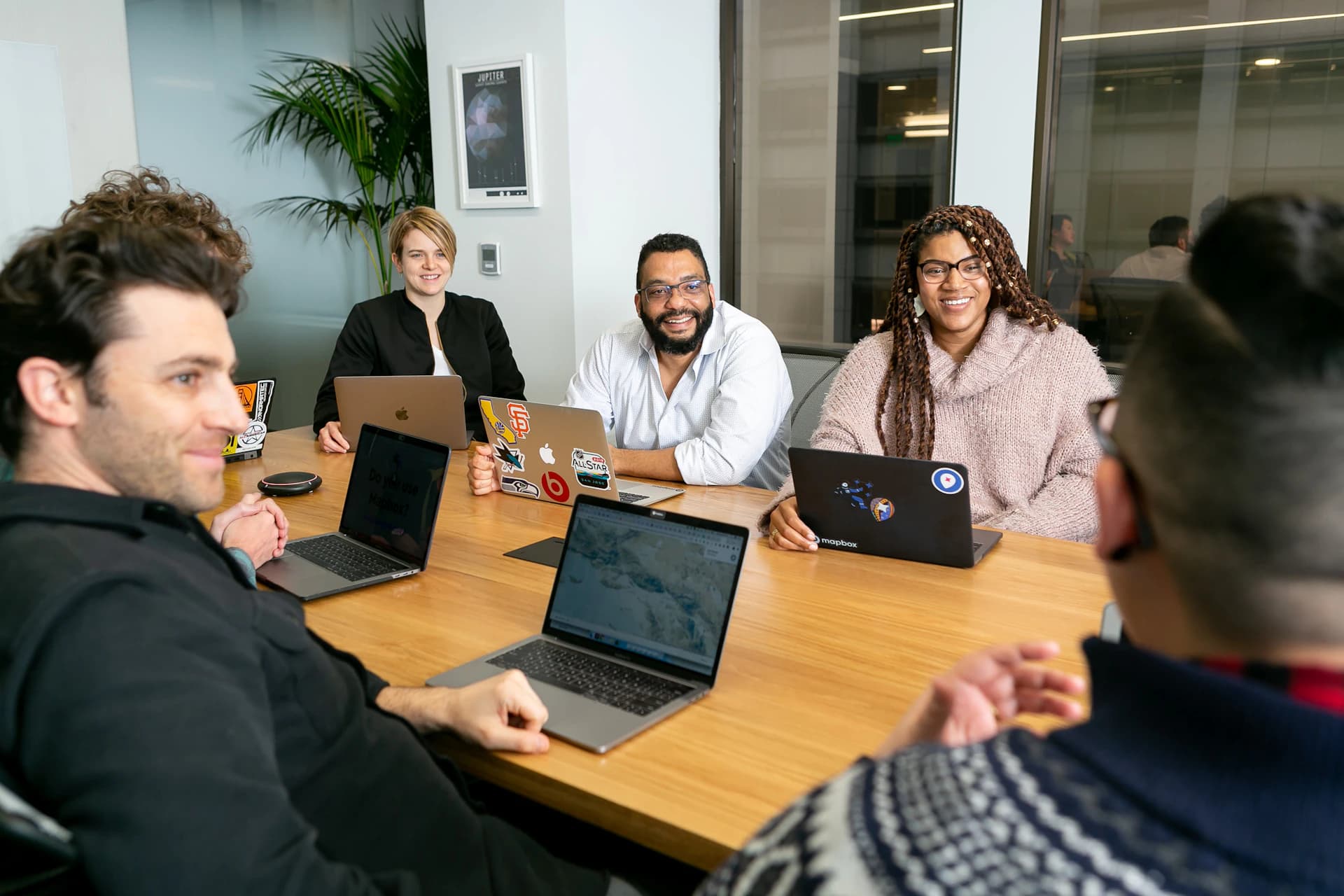 Equipe reunida em volta de uma mesa com notebooks